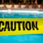 Infant Distraction Leads to Heartbreaking Drowning, No Charges! Yellow caution tape in front of a swimming pool