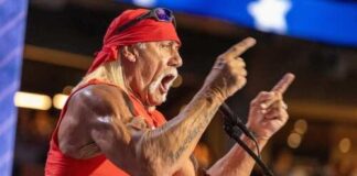 A muscular man in a red bandana passionately speaking at a podium