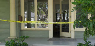A front porch with caution tape indicating a crime scene