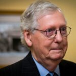 GOP Candidates Run from McConnell as MAGA Base Flexes Power Man with glasses standing in a room