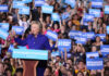 Hillary Clinton speaking at a political rally with a cheering crowd