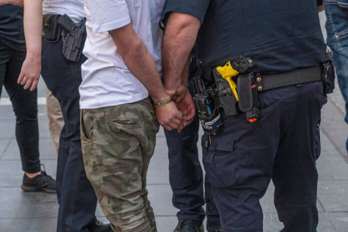 Person handcuffed by police on the street