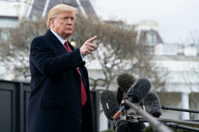 Man gesturing near microphones outside a building