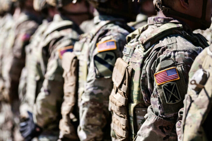 Military personnel in camouflage uniforms standing in line
