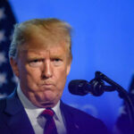 Massive Setback for Trump – Kentucky Loss Stings Man speaking at podium with microphones and flags