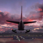 Airplane approaching airport runway at sunset sky