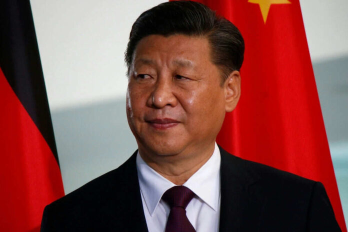 Person in suit with red and black flags behind