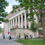 College Coach’s Mysterious Leave Stirs Controversy People walking outside a building with columns and trees