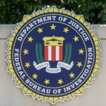FBI seal on stone wall with foliage background