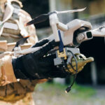 Terrifying Drone Swarm Vision Alarms Pentagon Camouflage soldier holding a drone with accessories attached