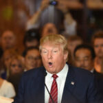 Man speaking at a crowded event with microphone