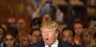 Man speaking at a crowded event with microphone