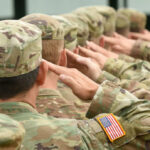 Owens’ Shocking Theory: U.S. Military Behind Kirk’s Death? Soldiers saluting in camouflage uniforms with flag patches