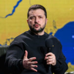 Man speaking into microphone with map background