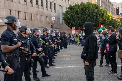 shutterstock_2643359513.jpg A standoff between police officers and protesters during a demonstration