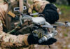 Person holding drone in camouflage uniform and gloves